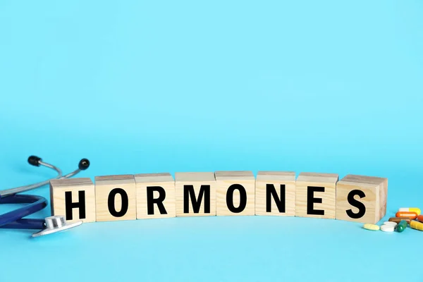 Word Hormones Made Wooden Cubes Letters Stethoscope Pills Light Blue — Stock Photo, Image