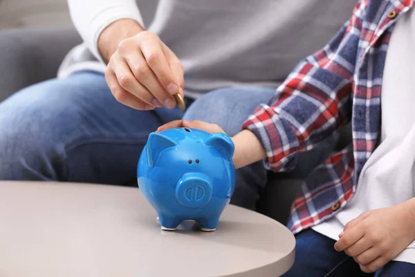 Little Boy His Father Putting Coin Piggy Bank Indoors Closeup — Zdjęcie stockowe