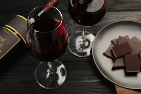 红葡萄酒和巧克力在黑木桌上的味道 — 图库照片