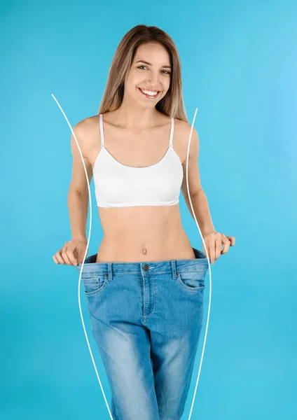 ライトブルーを基調にしたオーバーサイズのジーンズでスリムなボディの幸せな若い女性 重量損失 — ストック写真