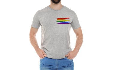 Beyaz arkaplanda LGBT gurur bayrağı resmi olan gri tişört giyen genç adam