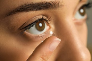 Genç kadının gözüne closeup Kontakt lens koyarak