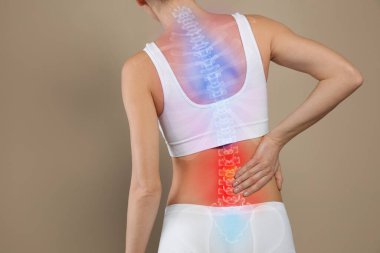 Woman suffering from pain in back on beige background, closeup clipart