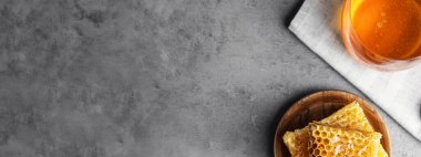 Gri masadaki taze, lezzetli bal petekleri, yazı için yeri olan üst manzara. Pankart tasarımı