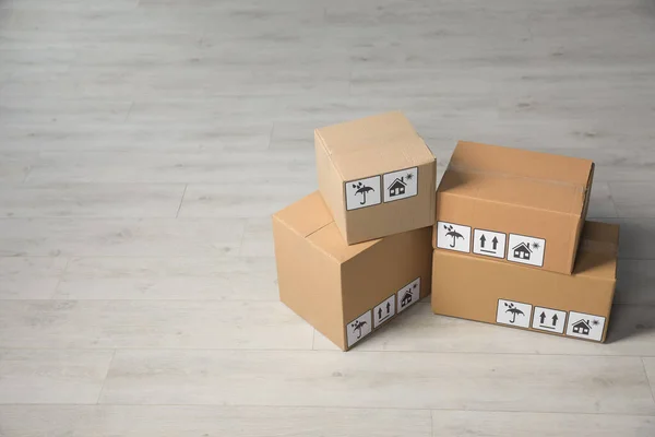 Many Closed Cardboard Boxes Packaging Symbols Wooden Floor Space Text — Stockfoto