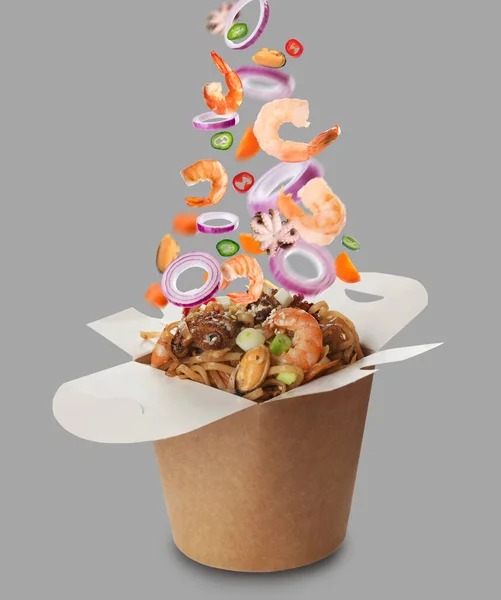 Different Fresh Ingredients Falling Box Wok Noodles Grey Background — Stock Photo, Image