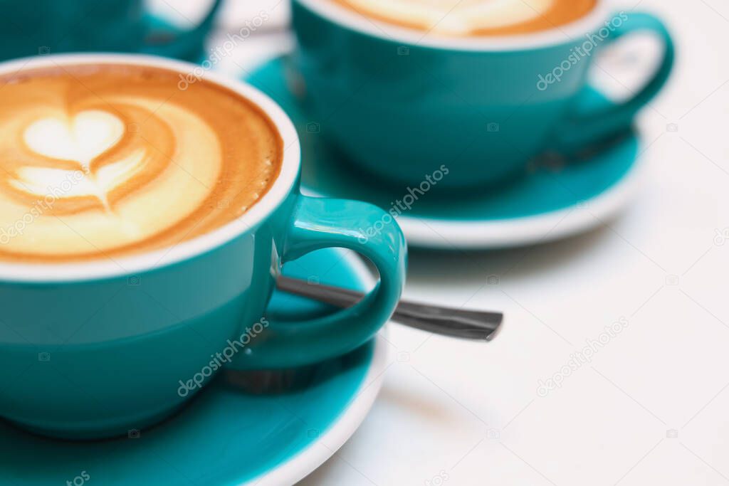Cups of aromatic coffee on beige background, closeup