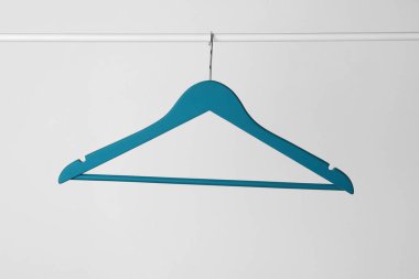 Mavi elbiseler arka planda metal parmaklıklara asılıyor.