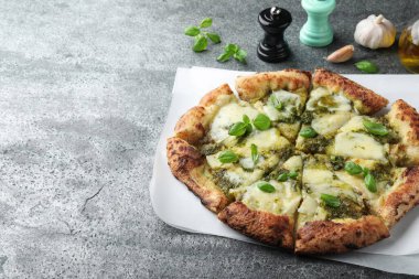 Gri masada pesto, peynir ve fesleğenli lezzetli pizza. Metin için boşluk