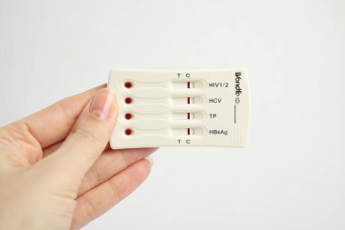Beyaz arka planda hepatit için tek kullanımlık ekspres test tutan kadın, yakın plan