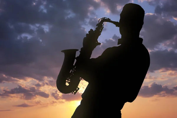 Silueta Del Hombre Tocando Saxofón Contra Hermoso Cielo Atardecer —  Fotos de Stock