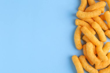 Açık mavi arka planda bir yığın leziz peynirli mısır gevreği. Metin için boşluk