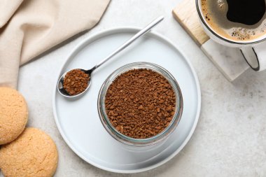 Cam kahve kavanozu, içkili fincan ve ışık masasında kurabiyeler, düz uzanma.