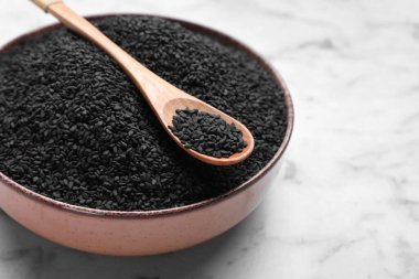 Siyah susam tohumlu kase ve kaşık beyaz mermer masa, yakın çekim