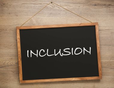 Ahşap duvarda INCLUSION sözcüğü asılı küçük karatahta