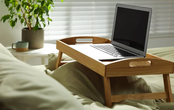 Holztablett Mit Modernem Laptop Auf Bett Drinnen — Stockfoto