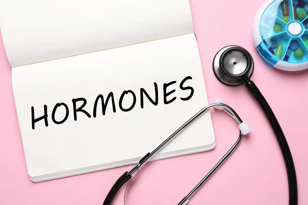 Notitieboek Met Woord Hormonen Stethoscoop Pillen Roze Achtergrond Plat Lay — Stockfoto