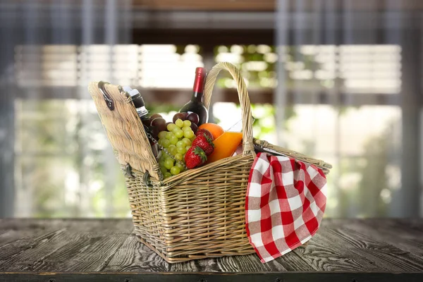 Weidenkorb Mit Wein Und Verschiedenen Produkten Auf Holztisch Drinnen — Stockfoto
