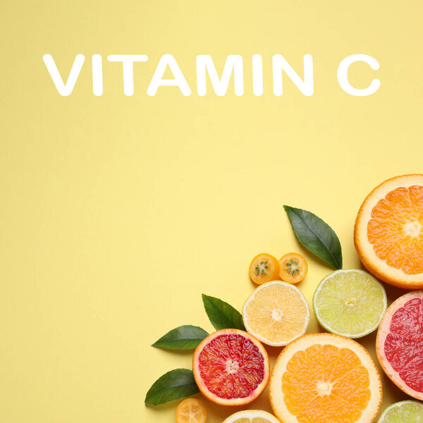 Источник витамина С. Свежие сочные цитрусовые с зелеными листьями на светло-желтом фоне, плоская укладка