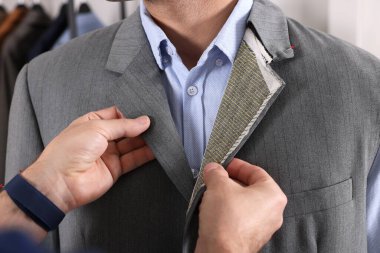 Atölyede müşteriyle çalışan profesyonel terzi, yakın plan