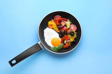 Turkuaz arka planda sebzeli leziz sahanda yumurta.
