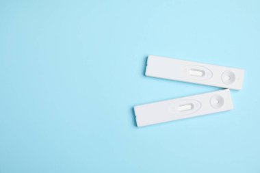 Açık mavi arka planda iki adet tek kullanımlık hepatit testi. Metin için boşluk