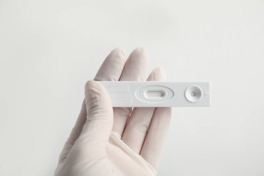 Beyaz arka planda hepatit için tek kullanımlık ekspres test tutan doktor, yakın plan