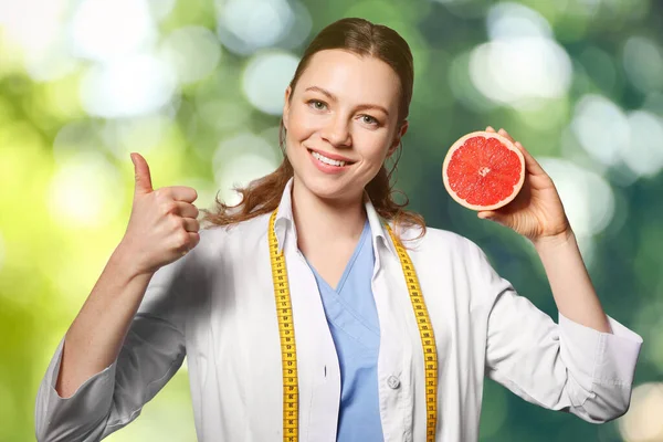 Voedingsdeskundige Met Grapefruit Wazig Groene Achtergrond — Stockfoto