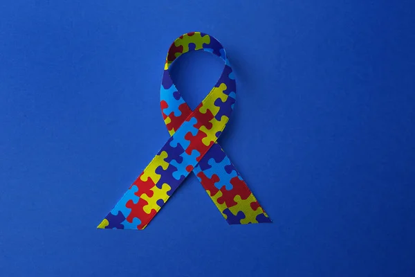 世界自閉症の日 青い背景のカラフルなパズルリボン トップビュー — ストック写真