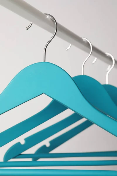 Empty Turquoise Clothes Hangers Metal Rail Light Grey Background Closeup — 스톡 사진