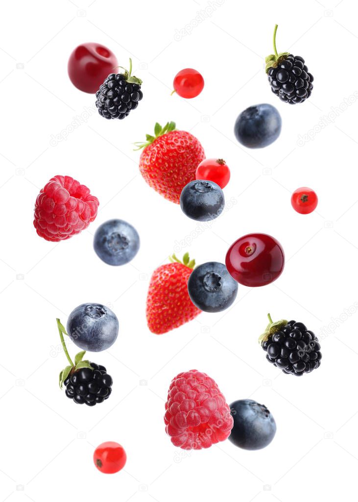 Different tasty ripe berries falling on white background