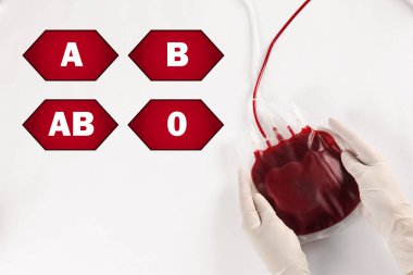 Farklı kan gruplarını temsil eden ikonlar ve açık gri arka planda kan nakli için kan taşıyan doktor.