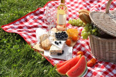Piknik battaniyesi ve yaz günü dışarıda lezzetli yemekler ve şarap.
