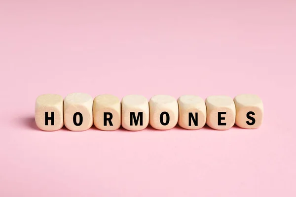 Word Hormonen Gemaakt Van Houten Kubussen Met Letters Roze Achtergrond — Stockfoto