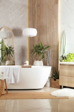 Modern beyaz küvet ve güzel yeşil bitkiler banyoda. İç tasarım