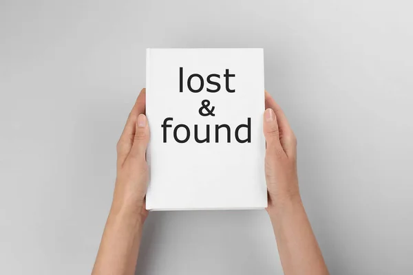 Woman Holding Book Phrase Lost Found Light Grey Background Closeup — Stock fotografie