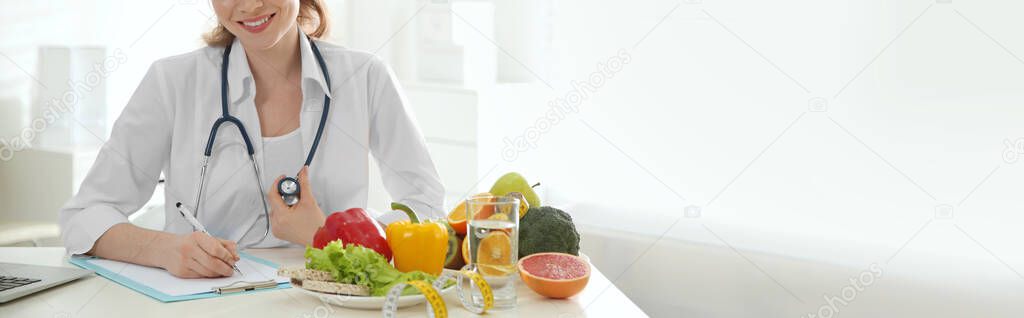 Nutritionist working at desk in office, closeup view with space for text. Banner design