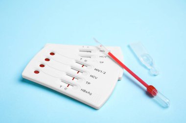 Açık mavi arkaplanda tek kullanımlık hepatit test kiti