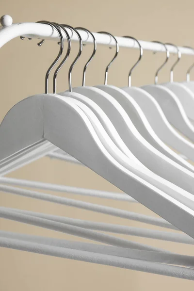 White Clothes Hangers Metal Rail Beige Background Closeup — 스톡 사진