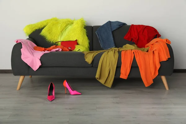 客厅的沙发和鞋子上堆满了五颜六色的衣服 — 图库照片