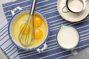 Fırça çırpma, yumurta, süt ve un, gri masa, düz uzanma