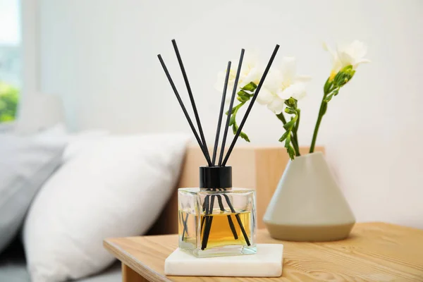 Schilfdiffusor Und Vase Mit Strauß Auf Hölzernem Nachttisch Schlafzimmer — Stockfoto