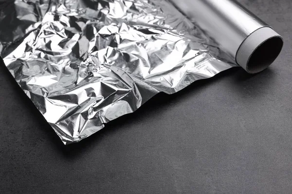 铝箔在深灰色桌子上的卷曲 — 图库照片