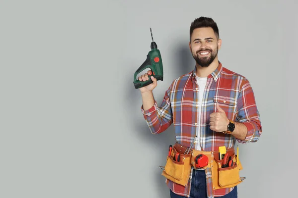 Young Worker Power Drill Tool Belt Grey Background Space Text — Stockfoto