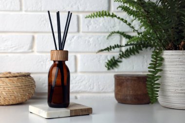 Air reed freshener on table against white wall