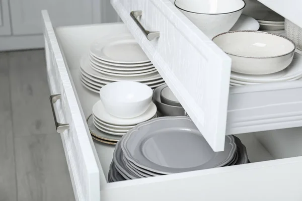 Ανοιχτά Συρτάρια Διαφορετικά Πιάτα Και Μπολ Στην Κουζίνα Closeup — Φωτογραφία Αρχείου