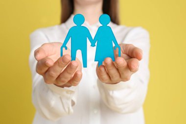 Sarı arka planda yaşlı bir çiftin resmini gösteren bir kadın, yakın plan. Emeklilik kavramı