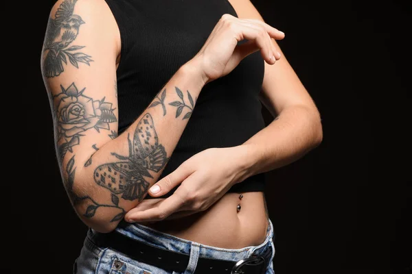 Kvinna Med Tatueringar Armen Mot Svart Bakgrund Närbild — Stockfoto