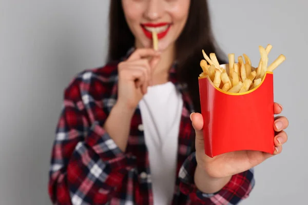 Beautiful Young Woman Eating French Fries Grey Background Closeup — Foto Stock
