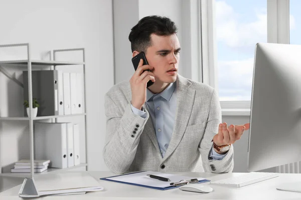 Confused Businessman Talking Phone While Working Office — ストック写真